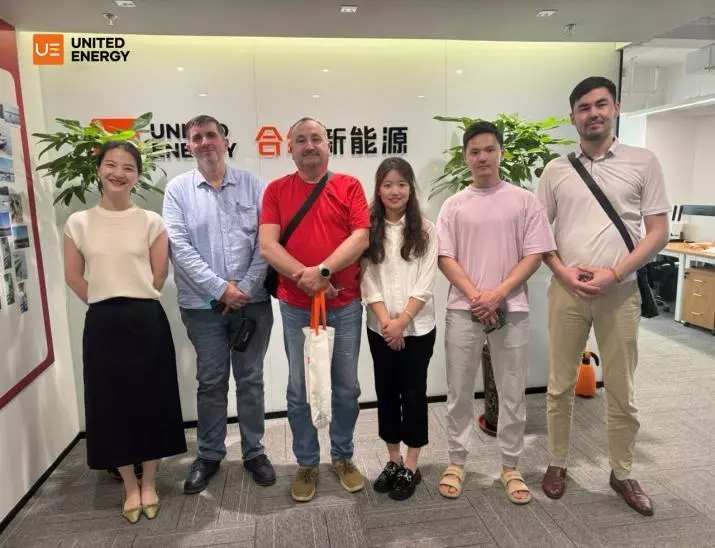 UE salesperson takes a photo with a customer in the office
